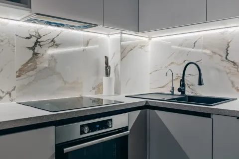 Modern kitchen with built-in cooktop, oven, and sink. - image 8