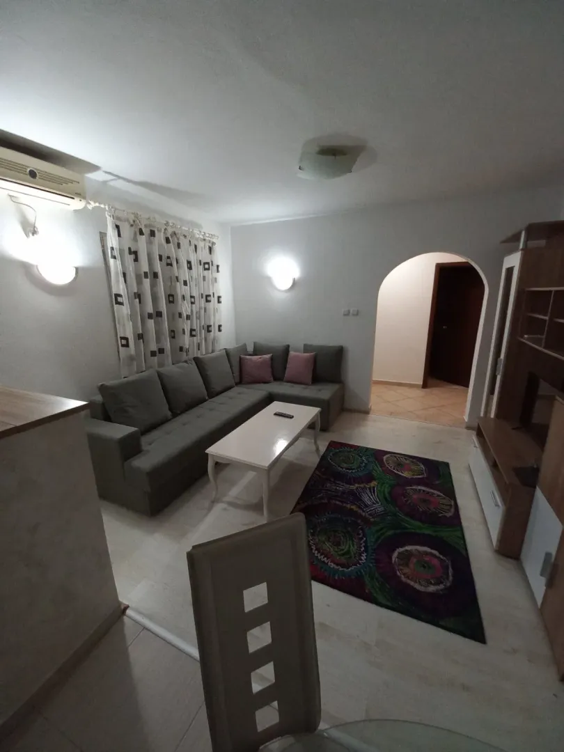 Dnevna soba sa garniturom, klub stolom i TV komodom.