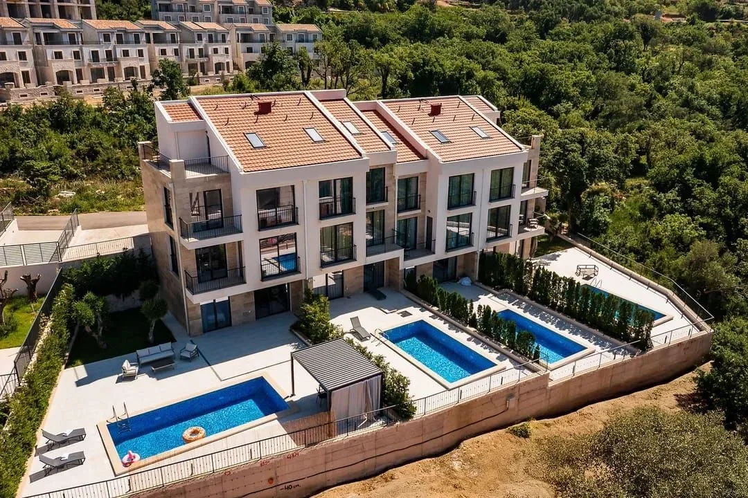 Pogled iz vazduha na stambeni objekat sa bazenima i uređenim dvorištem.