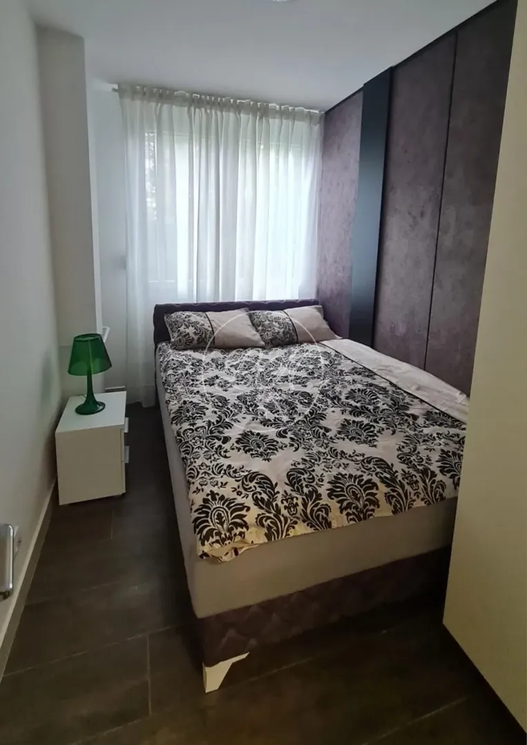 Bedroom with a double bed, nightstand, and a window.