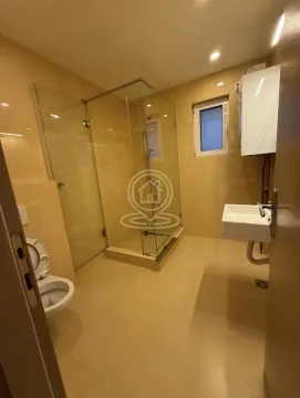Kupatilo sa tuš kabinom, umivaonikom i toaletom u bež tonovima. - image 13