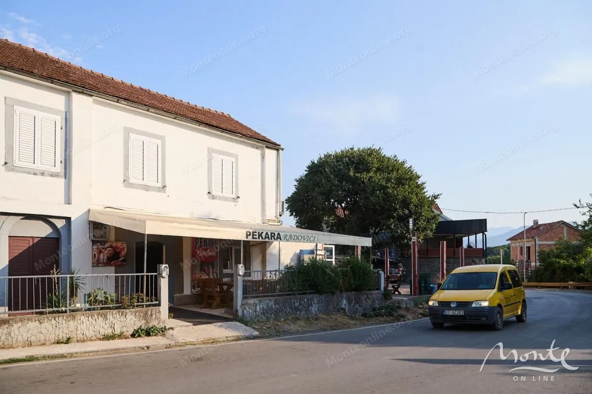 Pogled na spoljašnjost zgrade sa pekarom u prizemlju i ulicom u prvom planu.