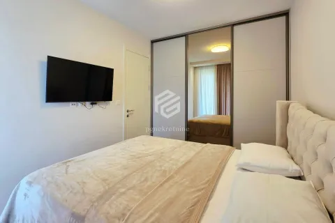 Furnished bedroom with a double bed, large wardrobe, and wall-mounted TV. - image 16