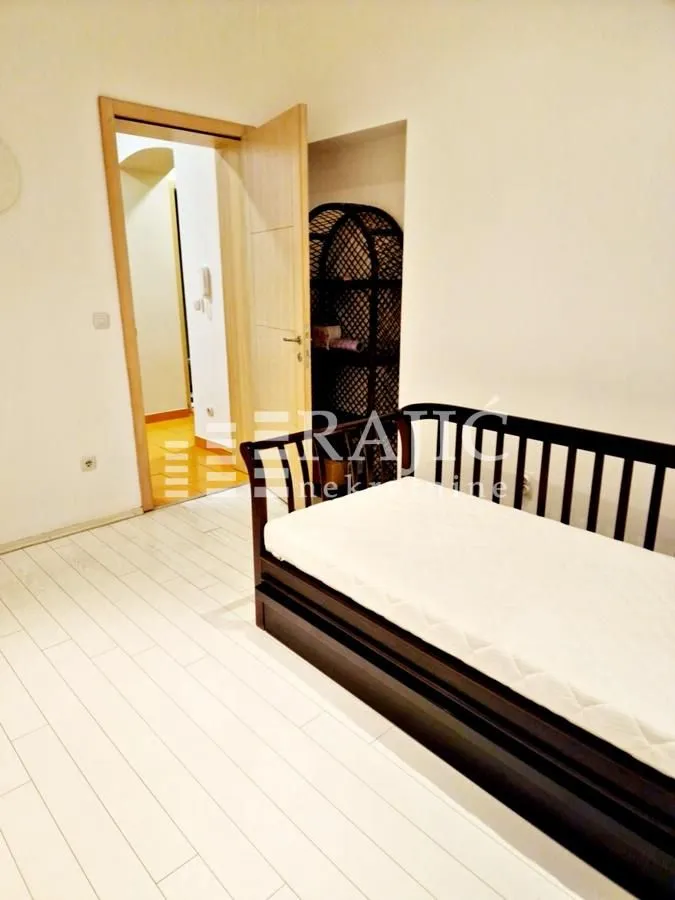 Small bedroom with a bed and an open passage to the hallway.