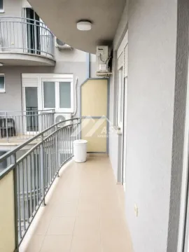 Pogled na duguljasti popločani balkon sa metalnom ogradom i spoljnom jedinicom klima uređaja. - image 9