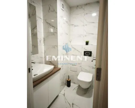 Modern bathroom lined with ceramic tiles featuring a marble pattern. - image 3