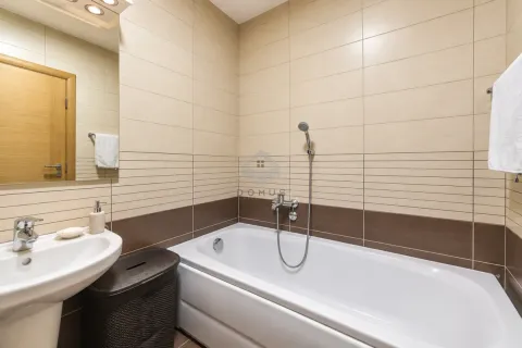 Bathroom equipped with a bathtub, washbasin, and mirror with ceramic wall tiles. - image 18