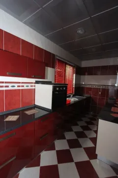 Kuhinja sa crvenim elementima i kariranim podom. - image 18