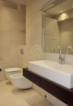 Modern bathroom with a sink, toilet, and bidet. - image 12