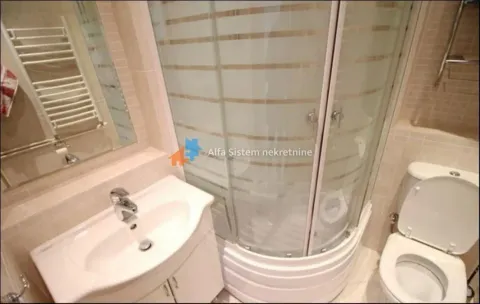 Bathroom equipped with a washbasin, shower cabin, and toilet. - image 30