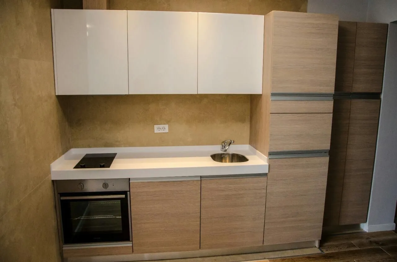 Modern kitchen with light cabinets and built-in appliances.