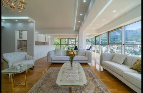 Spacious living room with white sofas and large glass surfaces with a view. - image 17