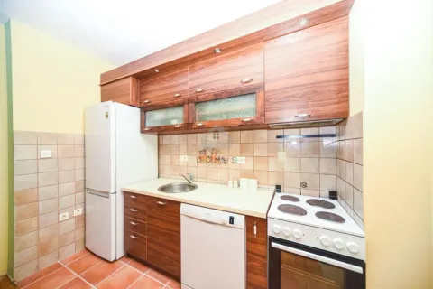 Kitchen with wooden cabinetry, refrigerator, and stove. - image 6