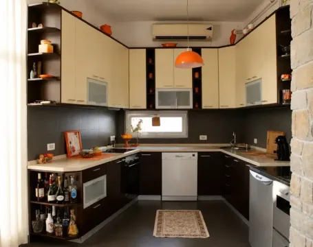 Equipped kitchen with dark and light cabinetry and built-in appliances. - image 13