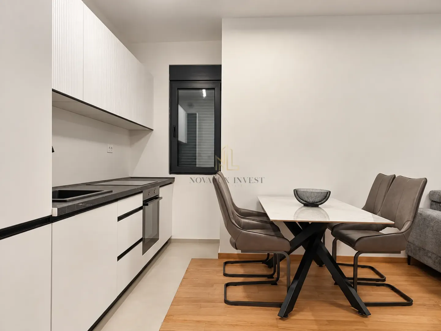 Modern kitchen with white cabinetry and a dining table with chairs.