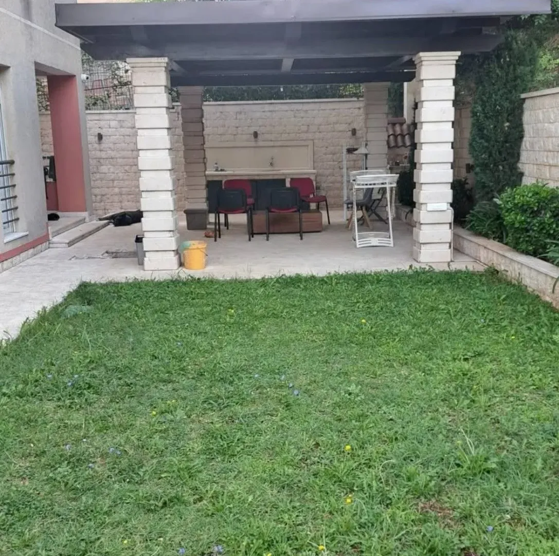Dvorište sa natkrivenom terasom i travnjakom.