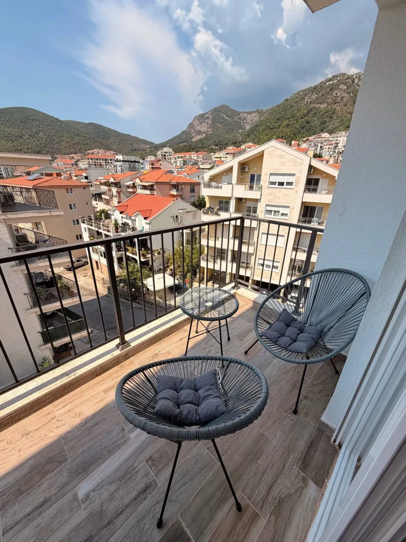 Namješten balkon sa garniturom za sjedenje i pogledom na grad.
