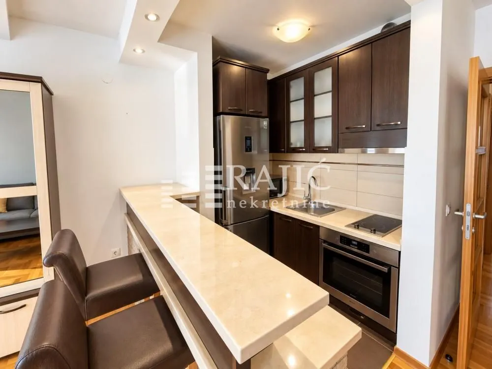 Modern kitchen with a bar counter and dining area connected to the living room.
