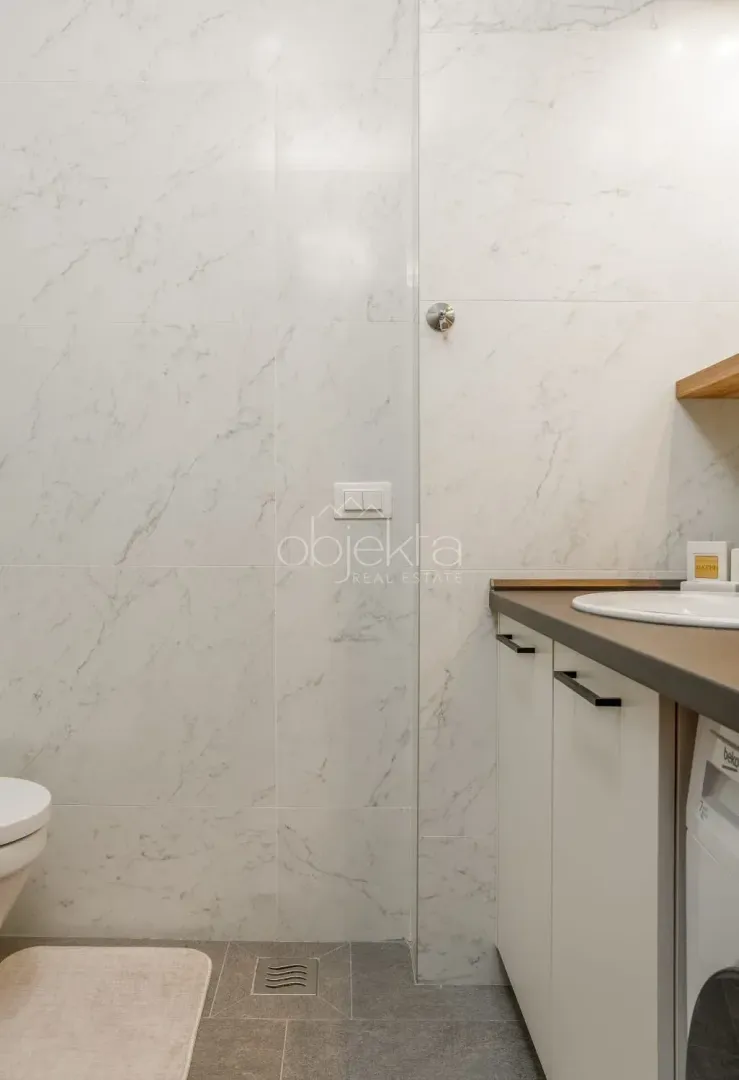Bathroom with ceramic tiles and a built-in washbasin.