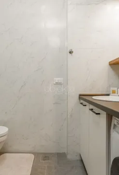 Bathroom with ceramic tiles and a built-in washbasin. - image 9