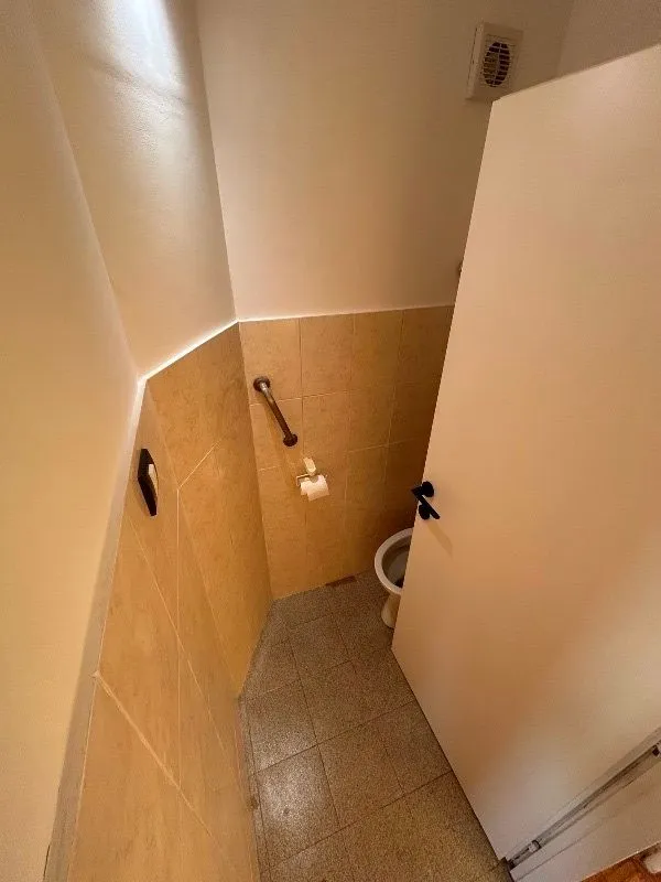 Pogled odozgo na manje kupatilo sa wc šoljom i keramičkim pločicama.