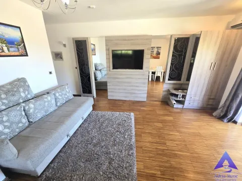 Dnevna soba sa garniturom za sjedenje, drvenim namještajem i televizorom. - image 7