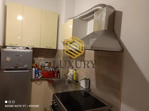 Small kitchen with beige cabinets, sink, and built-in cooktop. - image 4