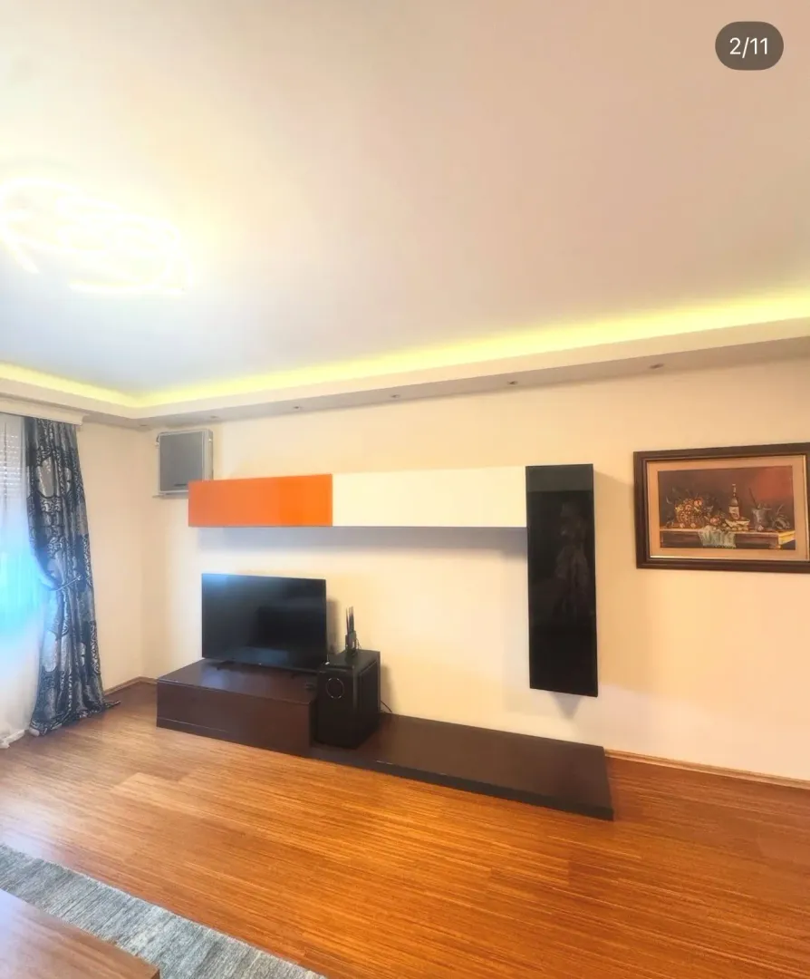 Living room with a TV unit and parquet flooring.