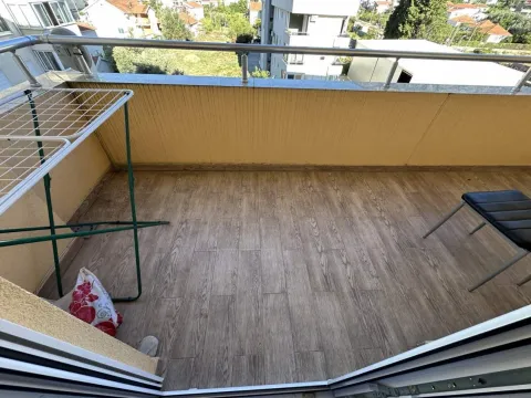Pogled na prostrani balkon sa drvenim podnim oblogama i metalnom ogradom. - image 12
