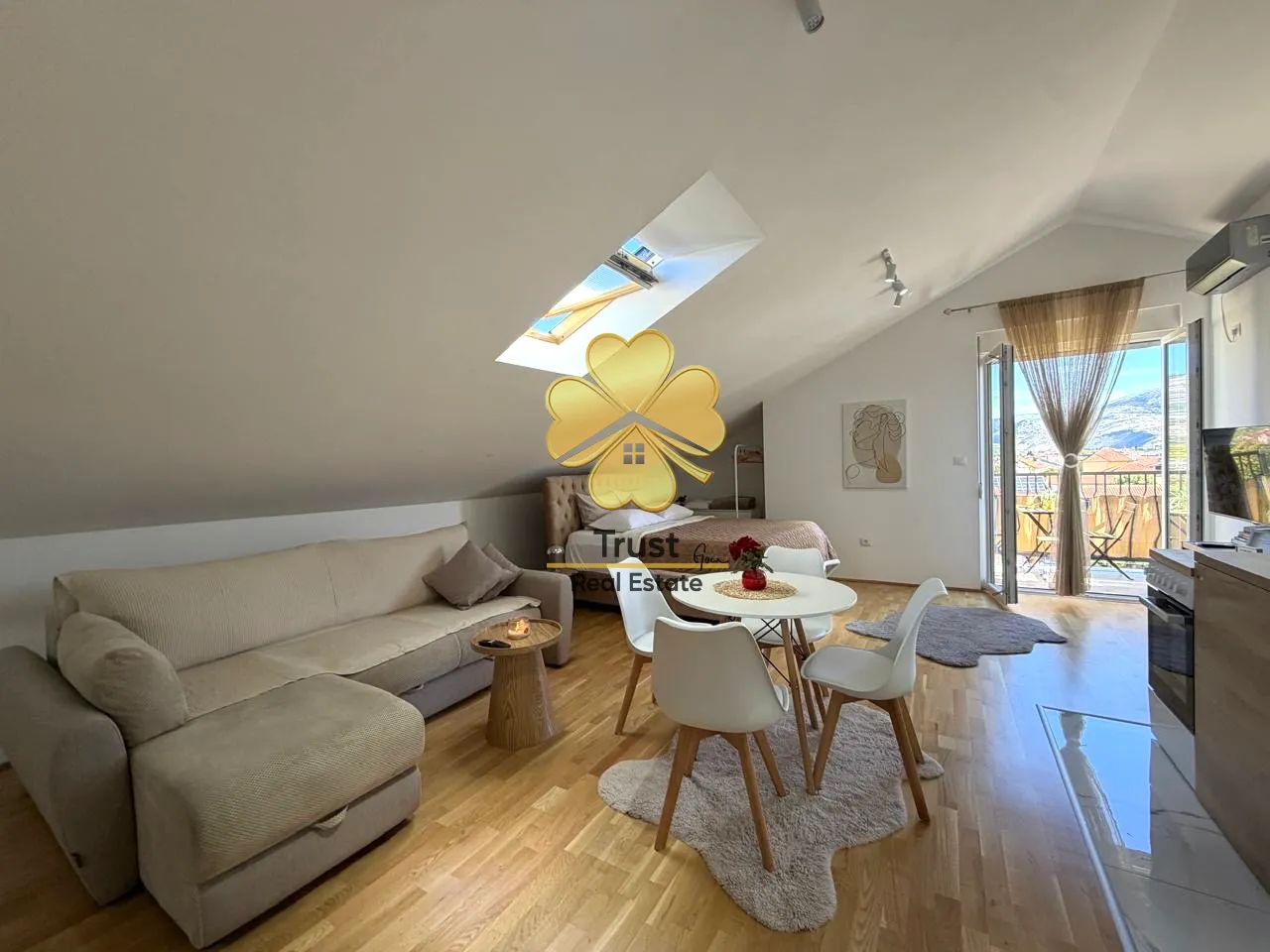 Attic apartment with a living room, dining area, and balcony access.