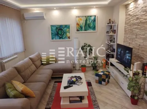 Furnished living room with a sectional sofa, TV, and decorative stone wall. - image 2
