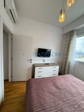 Spavaća soba sa bračnim krevetom, komodom i TV-om na zidu. - image 6