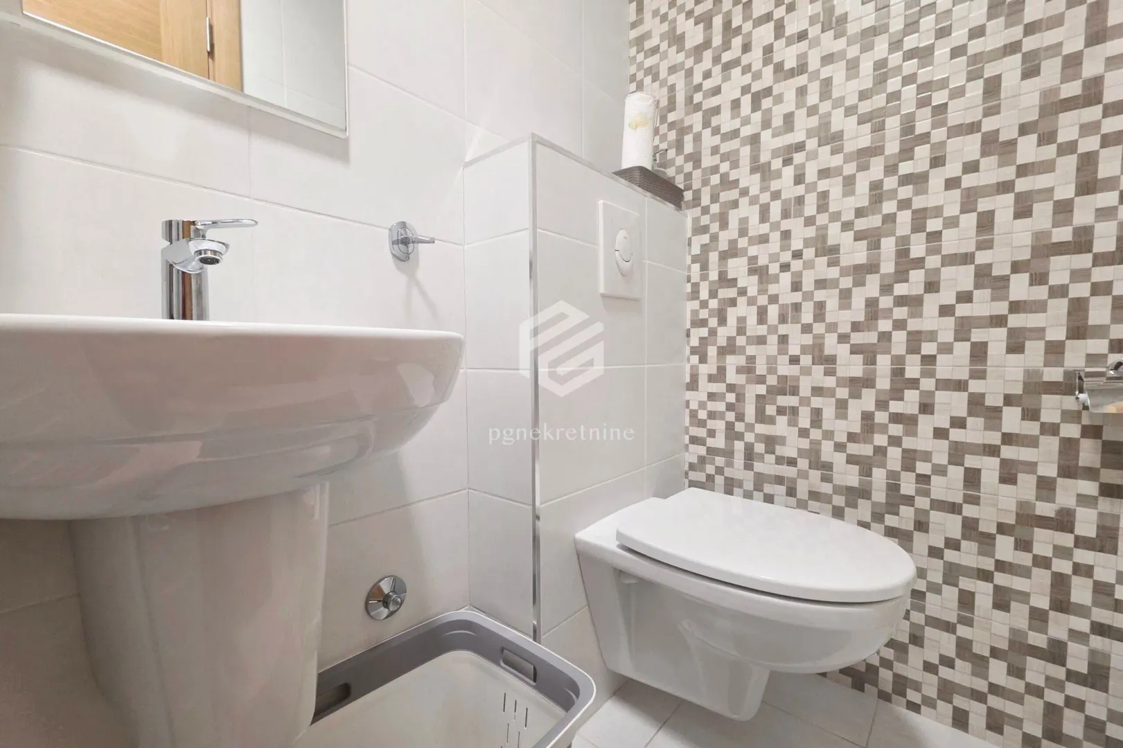 Small bathroom with a washbasin and a wall-hung toilet.