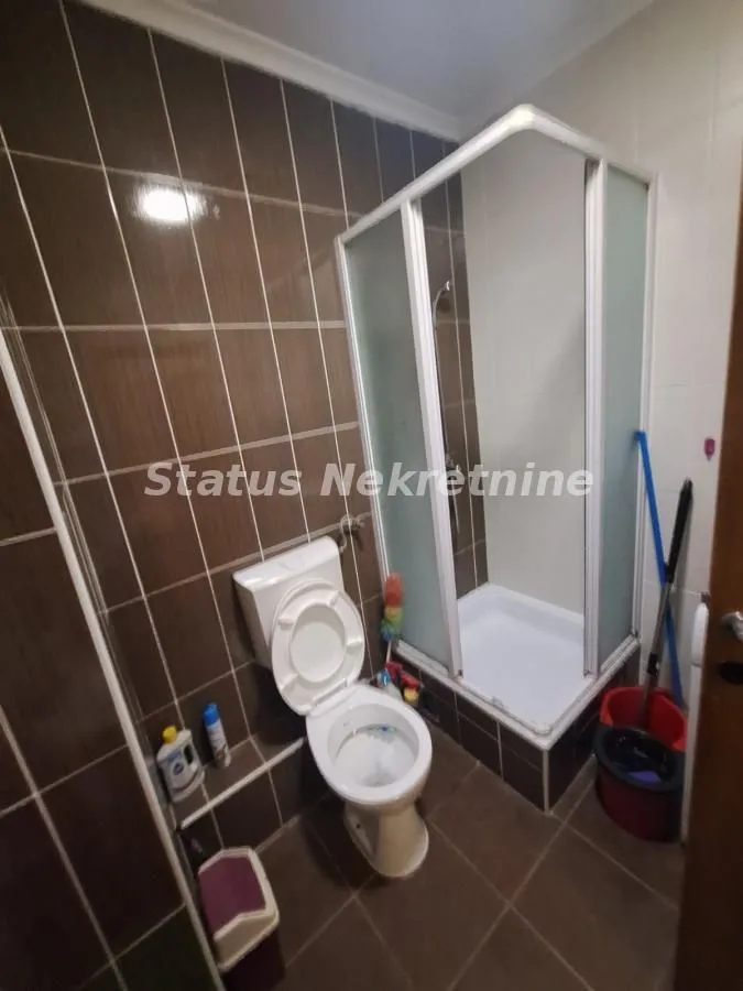 Kupatilo opremljeno tuš kabinom i sanitarijama.