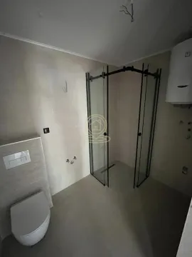 Kupatilo opremljeno tuš kabinom i ugradnom wc šoljom. - image 7