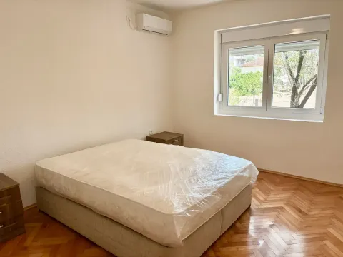 Empty bedroom with a bed and parquet flooring. - image 7