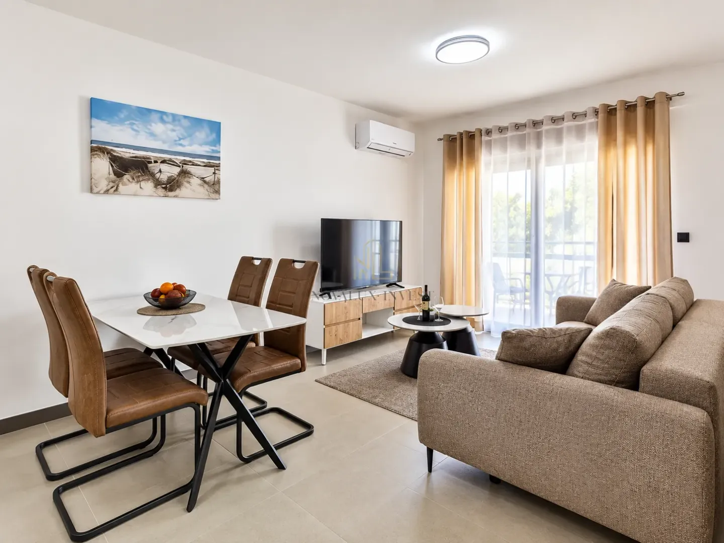 Living room with a sofa, dining table, and access to the terrace.
