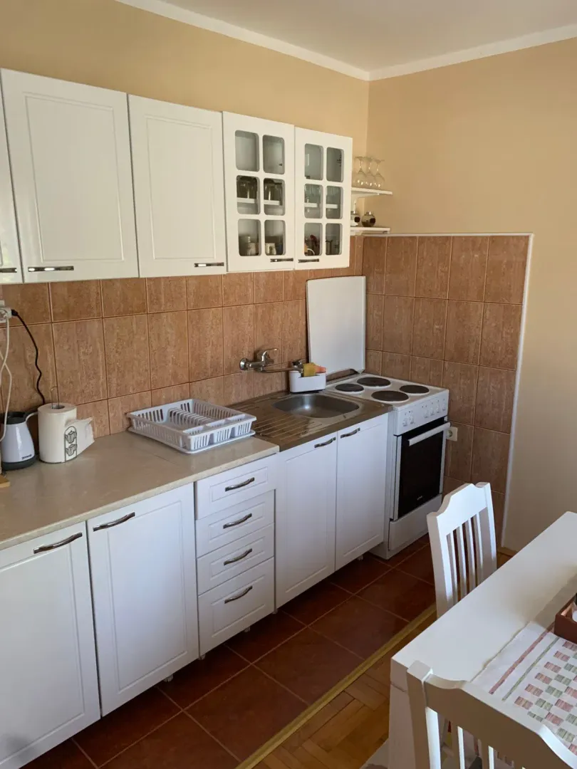 Small white kitchen with a stove and countertop.