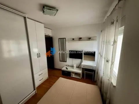 Nameštena spavaća soba sa krevetom, garderoberom i televizorom. - image 6