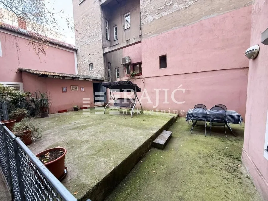 Inner courtyard of the building with a dining table and a swing.