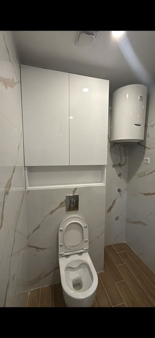 Modernly equipped bathroom with built-in units and a water heater.
