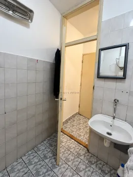 Small bathroom with a washbasin, mirror, and tiled floors and walls. - image 6