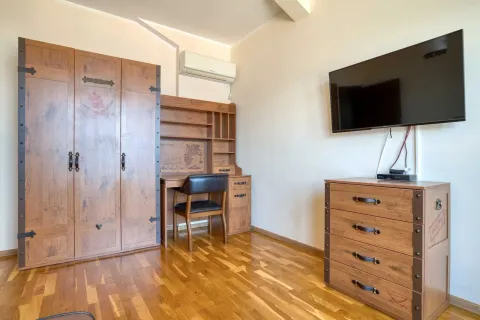 Dječija soba sa drvenim namještajem, radnim stolom i televizorom na zidu. - image 15