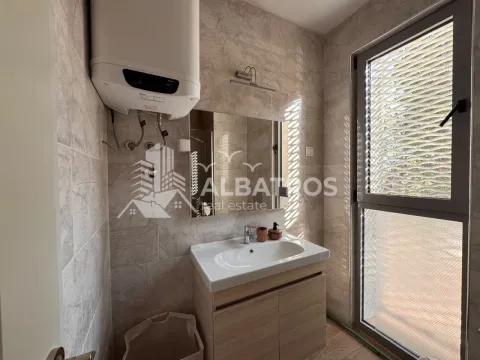 Smaller bathroom with a washbasin, mirror, water heater, and a window. - image 14