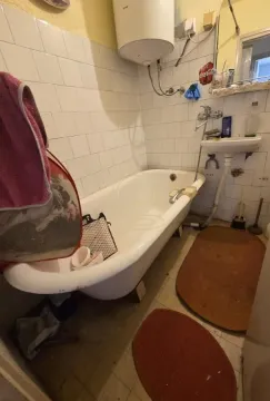 Starije opremljeno kupatilo sa kadom, bojlerom i umivaonikom. - image 13