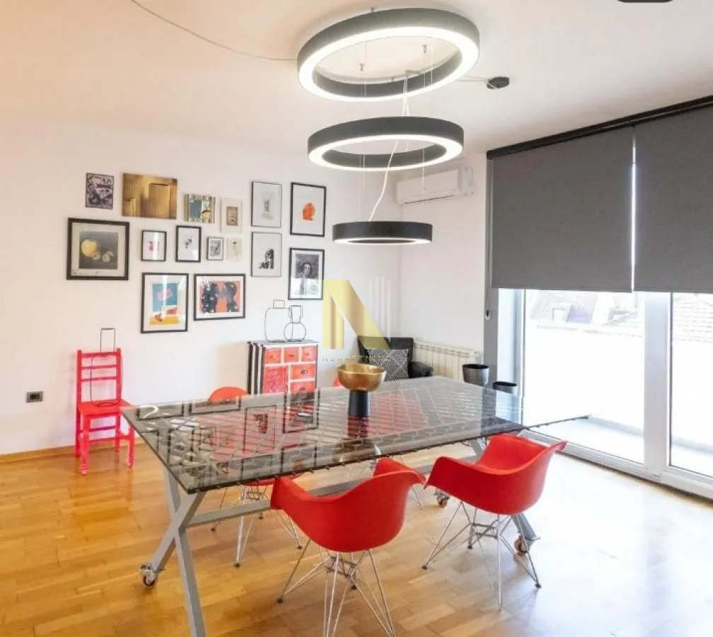 Dining room with a modern table, red chairs, and circular pendant lights.
