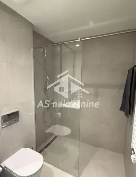 Modern bathroom with a walk-in shower and a wall-mounted toilet. - image 16
