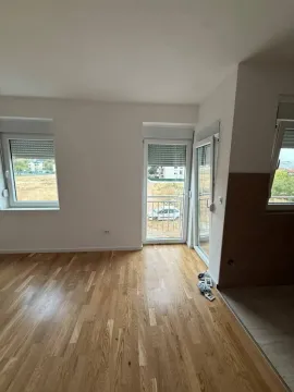 Prazna prostorija sa drvenim podom i izlazom na terasu. - image 3