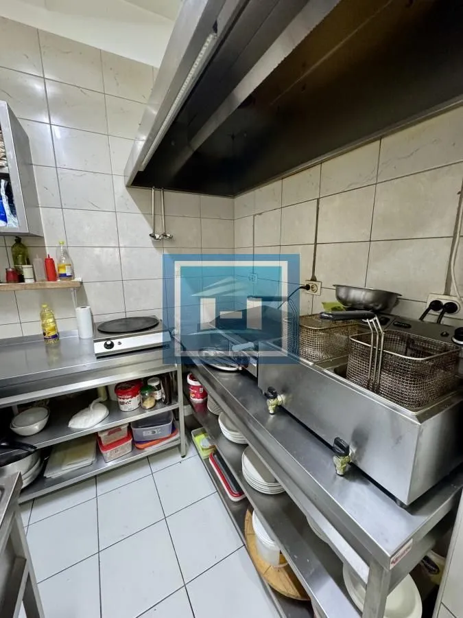 Komercijalna kuhinja sa inox radnim površinama i opremom za pripremu hrane.