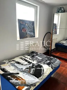 Small bedroom with a bed and a large mirror. - image 8